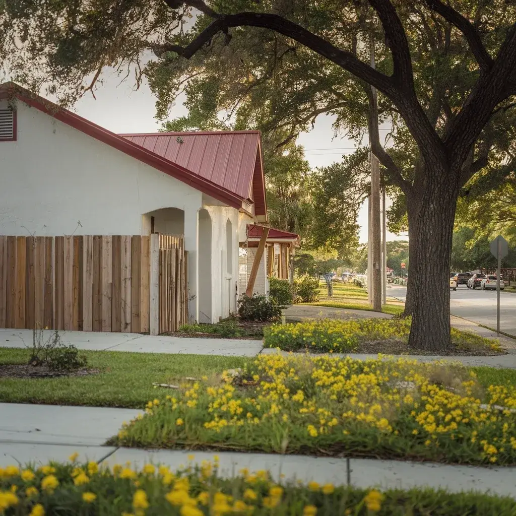 a white house with a red roof and a fence